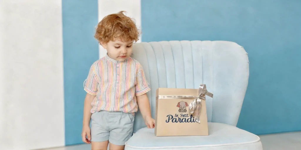 Niño con una bolsa de regalo de Le Petit Paradis
